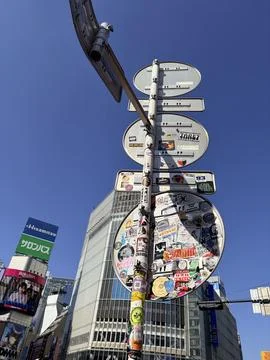 Low angle view of sticker covered road signs near Shibuya Crossing with urb.. Stock Photos