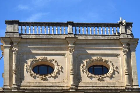 A low-angle view of a stone building with a balustrade. The facade features t Stock Photos