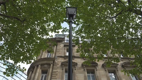 A low angle view of a street lamp beside an old stone building. Stock Footage 107940200