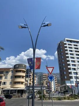 Low-angle view of a street lamp pole displaying the flags of Montenegro Stock Photos