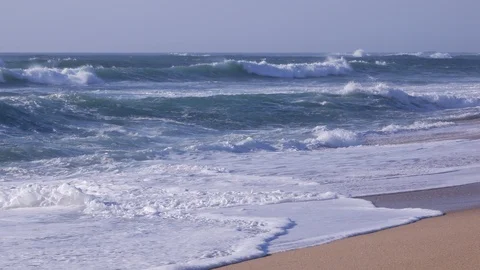 Low angle view of strong white surf waves crashing on the sandy beach Stock Footage 105159609