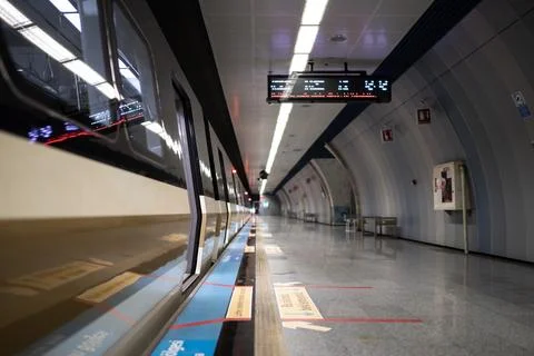 Low angle view of a subway train along a deserted station platform Stock Photos