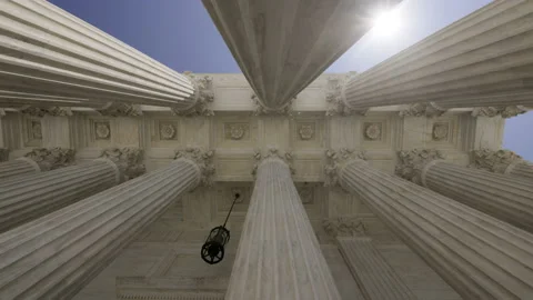 Low Angle View of the Sun Appearing Behind Columns of the Supreme Court Stock Footage 218449324