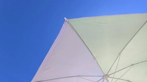 Low angle view of a Sun umbrella sunshade in a beach with blue sky in background Stock Footage 137791078