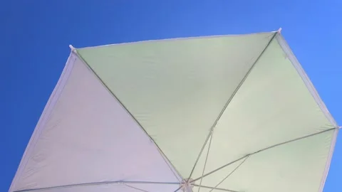 Low angle view of a Sun umbrella sunshade in a beach with blue sky in background Stock Footage 137791086