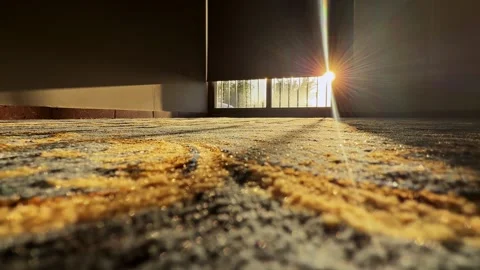 Low-angle view of sunburst through window blinds over patterned carpet in empty Stock Footage 333149327