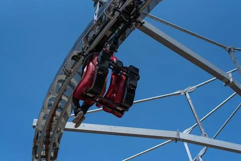 Low-angle view of a suspended roller coaster car on a curved track Stock Photos