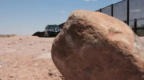 Low Angle View of SUV driving along US/Mexico Border Fence  Stock Footage 11515144