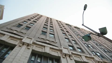 Low-angle view of a tall building against a bright sky. Vídeo Stock 345004848