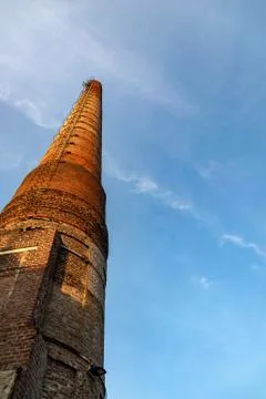 Low angle view at a tall chimney at sundawn Foto stock