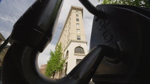 Low angle view of tall city building seen through a iron sculpture Stock Footage 103426250