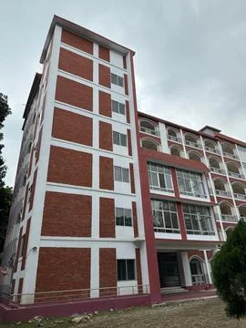 Low angle view of a tall multi story building facade displaying brick pattern Fotos Stock