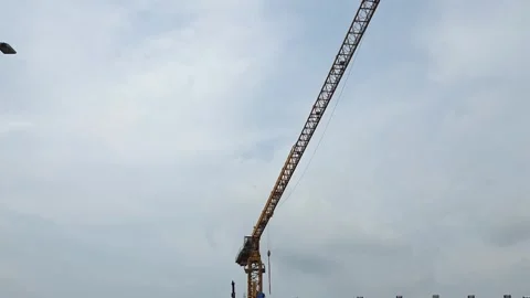 Low angle view of a tall yellow construction tower crane jib Stock Footage 336039897