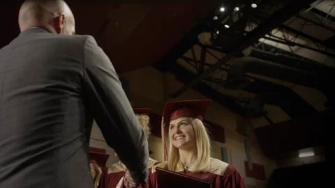 Low angle view of teacher shaking student's hand during graduation ceremony 스톡 사진