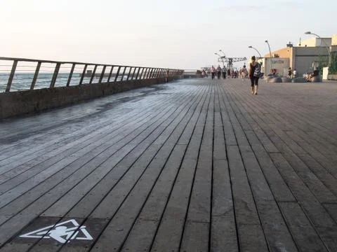 Low angle view of Tel Aviv port wooden boardwalk at sunset with people walking Foto stock