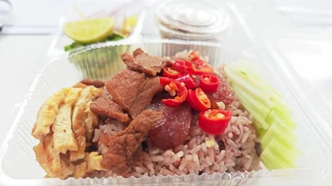 Low-angle view of Thai shrimp paste rice in a delivery box. Видео 348156549