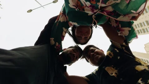 Low angle view of three young adults in casual clothing forming a huddle wi.. Stock Footage 262136226