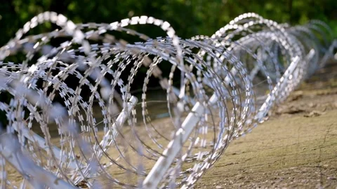 Low-Angle View Through a Tunnel of Coiled Razor Wire Stock-Footage 344121199