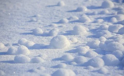 Low-angle view of tiny snowballs on snow surface, Finland Stock Photos