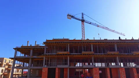 Low angle view of tower crane above concrete building frame Stock Footage 335690869