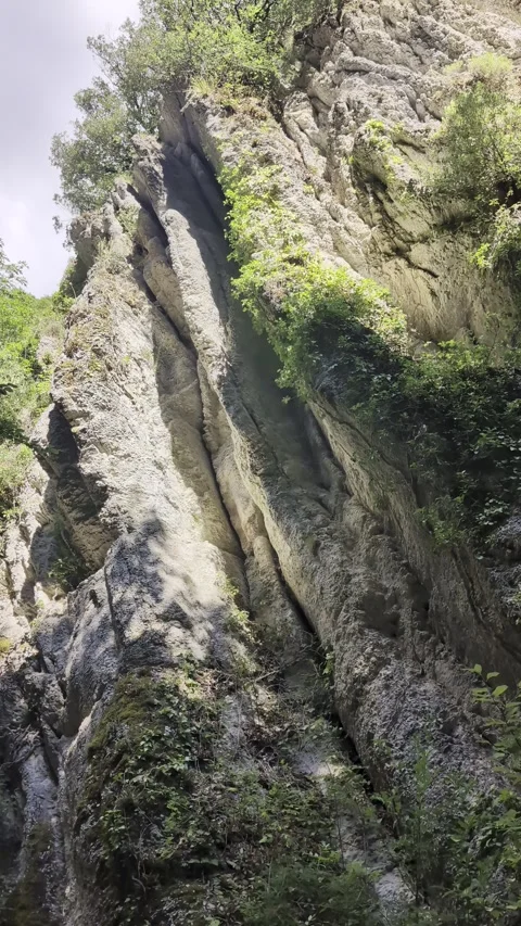 Low angle view of a towering rocky cliff face Stock Footage 344307298