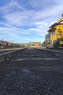 Low angle view train track with coal and soot remains and people on platform Foto stock