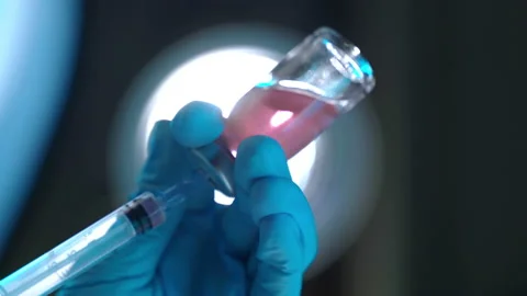 Low angle view of transparent vial with lightly red solution on contrast lights Video stock 146209457