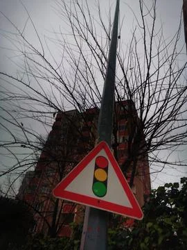 Low angle view of a triangular traffic light warning sign on a metal pole, with Stock Photos