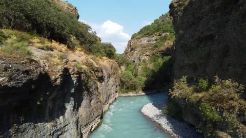 Low angle view of turquoise river flowing through deep rocky canyon  Vidéo 334323855