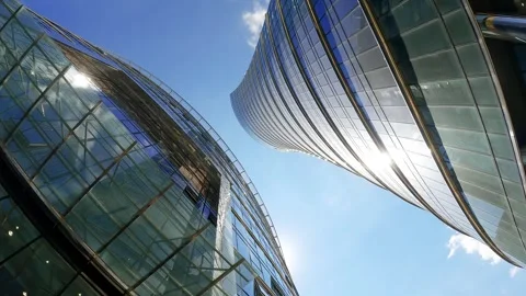 Low angle view of twisting modern glass office skyscrapers Stock Footage 345139003