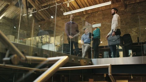 Low angle view of two businessmen greeting and talking in office corridor Stock Footage 107903788