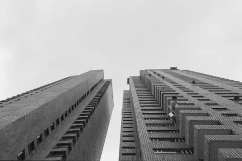 Low angle view of two symmetrical brick tall buildings with blue cloudy sky Foto stock