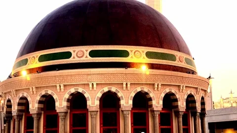 A low-angle view of two tall, illuminated minarets rising behind a dark Stock Footage 346926617
