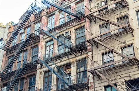 Low Angle View of Typical Apartment Buildings with Fire Escape Ladders in NYC Stock Photos