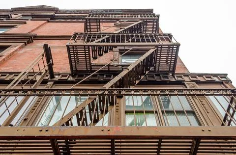 Low Angle View of Typical New York City Apartments with Fire Escape Ladders Stock Photos