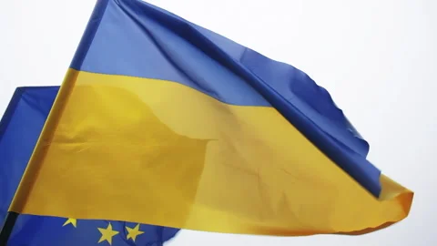 Low Angle view of Ukraine and EU flags waving on grey background Stock Footage 246313719