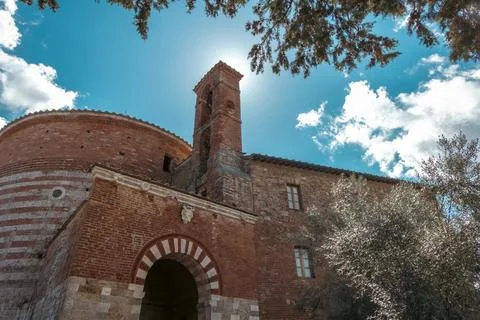 Low angle view from under a tree of a medieval church with blue sky in the Stock Photos