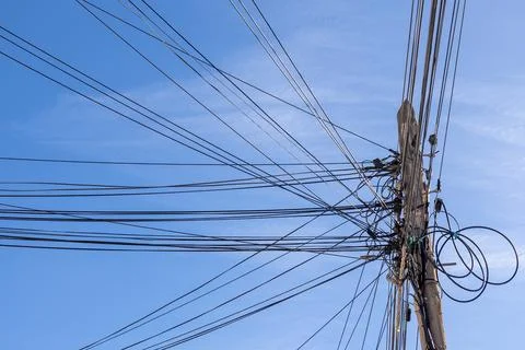 Low angle view of a utility pole with numerous power and communication line.. Stock Photos