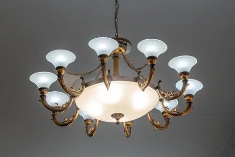 Low angle view of a vintage round chandelier with ten lamps. Classic bronze.. Фото