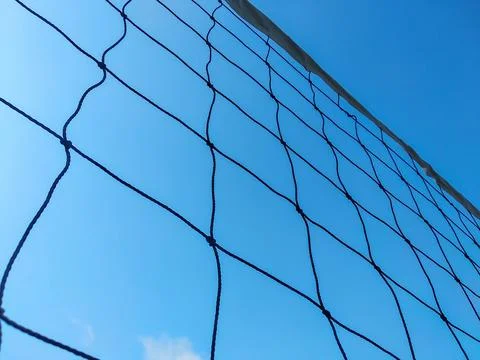 Low-angle view of a volleyball net against a clear blue sky background Stock Photos