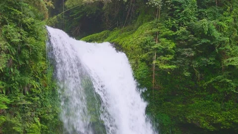 Low angle view of waterfall drop with rich green mountain slopes in background Stock-Footage 341806334