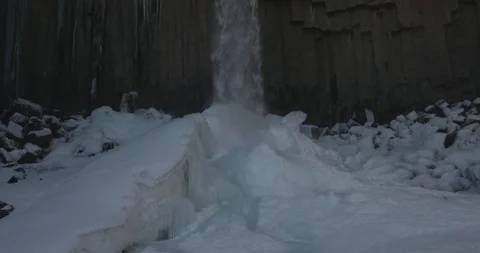 Low angle view of waterfall falling off the high eroded cliff during winter Video stock 103807771