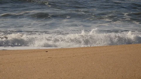 Low angle view of waves lapping on shore of a sandy beach, sunny day Stock Footage 103280049