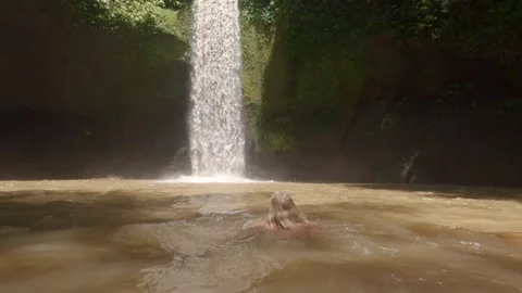 Low-Angle view of white blonde woman swimming in plunge pool under hidden Stock Footage 328928867