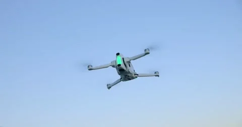 Low Angle View of White Drone Hovering in Blue Sky Stock Footage 343928192