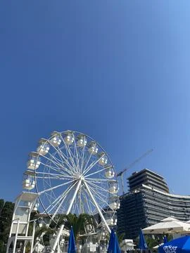 Low-angle view of a white Ferris wheel set against a clear blue sky Stock Photos