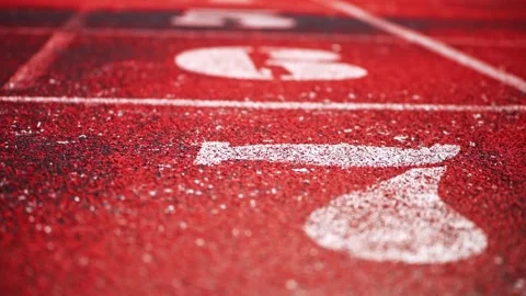 Low-Angle View of White Lane Markings and Starting Numbers on Athletics Track Stock-Footage 340482888