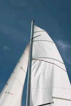 Low angle view of white sail and mast billowing against clear summer sky Stock Photos