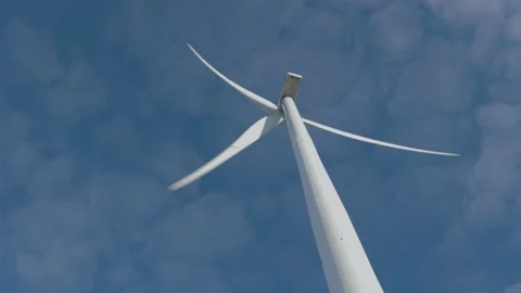 Low angle view of wind turbine against a blue sky. Renewable energy concept. Stock Footage 148426940
