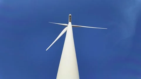 Low-angle view of a wind turbine against a vibrant blue sky. Stock Footage 301767167